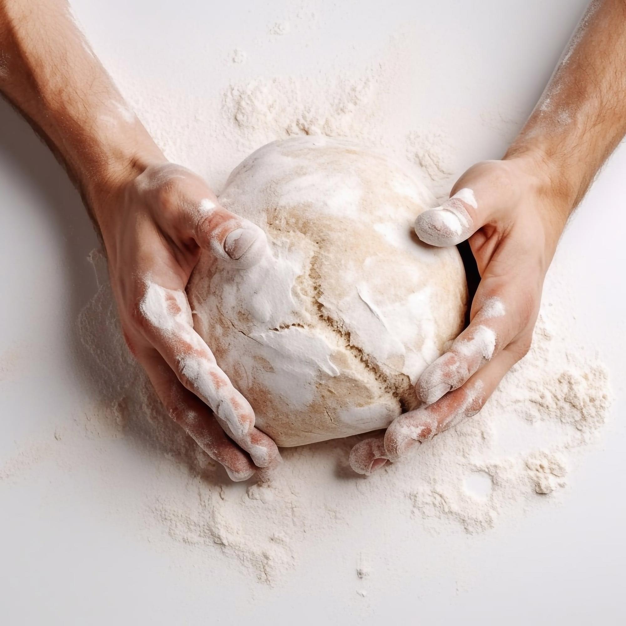Close-up of hands kneading dough in a bright kitchen