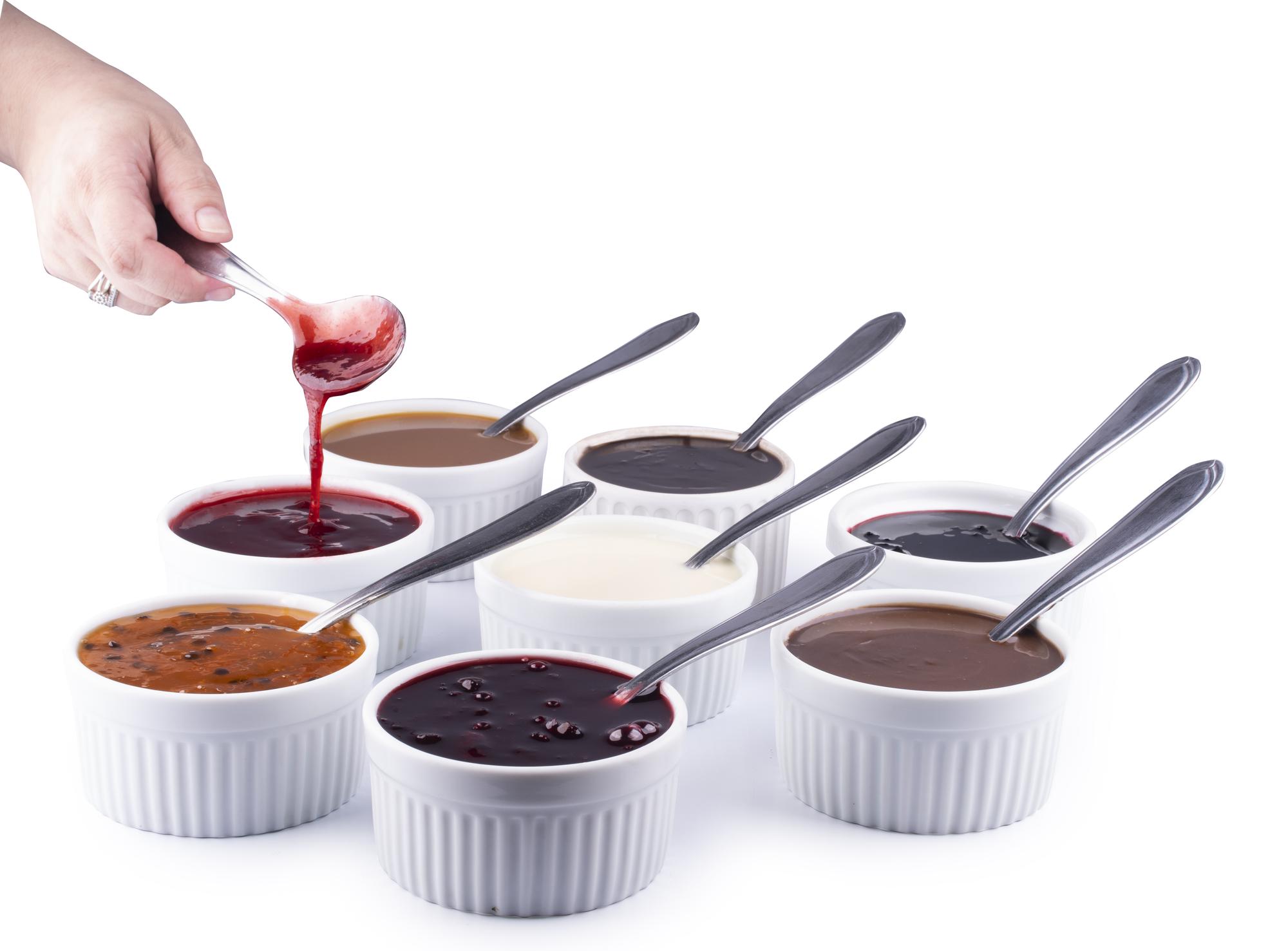 Students tasting a sauce from spoons